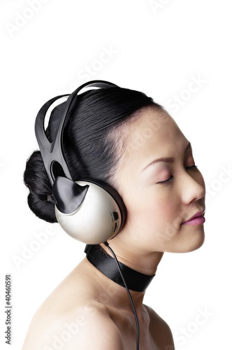 Foto: Woman listening to music on the headphones. Woman listening to music on the headphones.