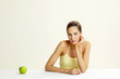 Woman posing with a green apple.