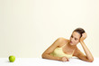 Woman looking at a green apple.