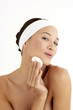 Foto: Woman applying makeup on her face. Woman applying makeup on her face.