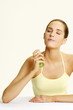 Woman spraying mist on her neck.