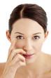 Foto: Woman putting on contact lens. Woman putting on contact lens.
