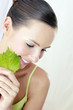 Woman holding green leaf.