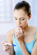 Woman looking worried with her pregnancy test results.