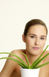Woman posing with a pot of aloe vera.