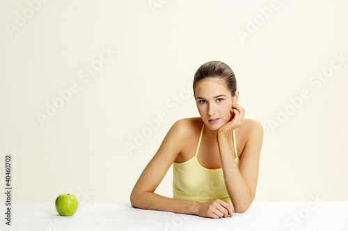 Photo: Woman posing with a green apple. Woman posing with a green apple.