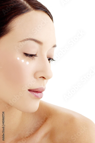 Photo: Woman with three dots of moisturiser across her cheek. Woman with three dots of moisturiser across her cheek.