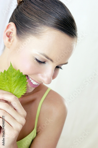 Photo: Woman holding green leaf. Woman holding green leaf.