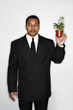Foto: Businessman holding a pot of plants. Businessman holding a pot of plants.