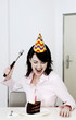 Woman trying to hammer her birthday cake.