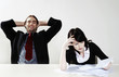 Businessman relaxing while his colleague is busy with her work.