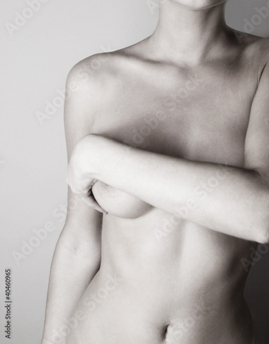 Photo: Naked woman covering her breasts with her hand. Naked woman covering her breasts with her hand.