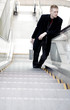 Businessman standing on an escalator.