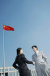 Businessman and businesswoman shaking hands.