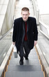 Businessman standing on an escalator.
