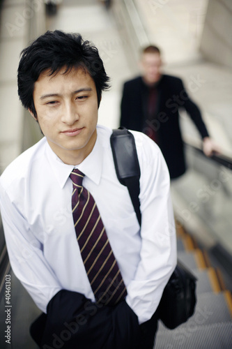 Photo: Businessman standing on an escalator. Businessman standing on an escalator.