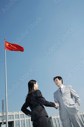 Photo: Businessman and businesswoman shaking hands. Businessman and businesswoman shaking hands.