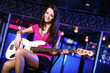 Young guitar player performing in night club