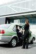 Photo: Businesswoman greeting her client from the taxi. Businesswoman greeting her client from the taxi.