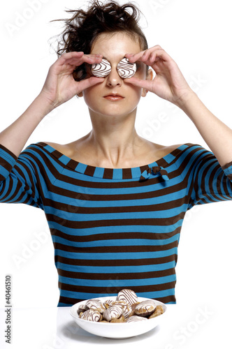Photo: Woman covering her eyes with cookies. Woman covering her eyes with cookies.
