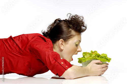 Foto: Woman eating a bowl of salad. Woman eating a bowl of salad.