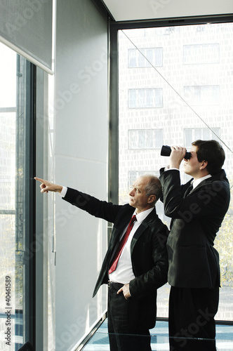 Photo: Businessman using binoculars. Businessman using binoculars.