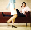 Businessman checking out a woman while talking on the handphone.