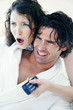 Couple watching a shocking programme on the television.