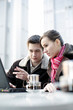 Couple sharing laptop at a cafe.