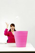 Businesswoman throwing a crumpled paper into a dustbin.