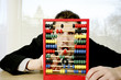 Businessman playing with children abacus.
