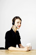 Businesswoman holding a cup of coffee while answering calls.