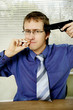 Businessman pointing a pistol at himself while smoking cigarette.
