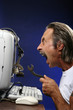 Photo: Man getting frustrated while fixing his computer. Man getting frustrated while fixing his computer.