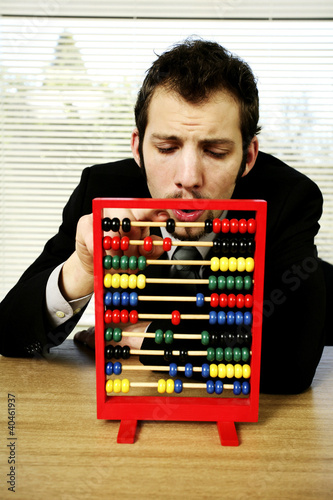 Photo: Businessman playing with children abacus. Businessman playing with children abacus.