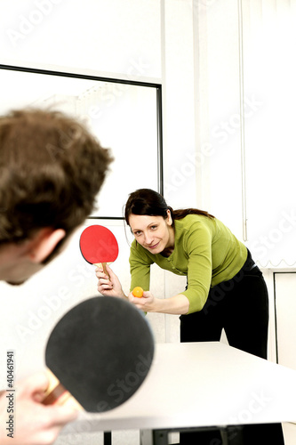 Photo: Businessman and businesswoman playing table tennis. Businessman and businesswoman playing table tennis.