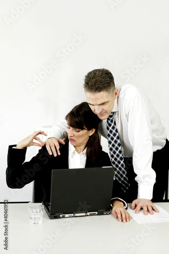Photo: Businessman taking advantage of his female colleague. Businessman taking advantage of his female colleague.