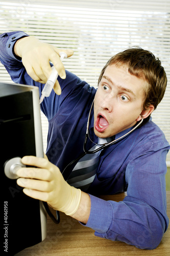 Photo: Businessman saving his computer from virus. Businessman saving his computer from virus.