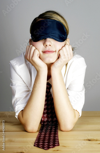 Photo: Businesswoman covering her eyes with an eye mask. Businesswoman covering her eyes with an eye mask.