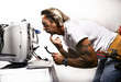Photo: Businessman trying to fix his computer. Businessman trying to fix his computer.