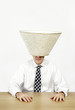 Businessman with a lamp shade covering his head.