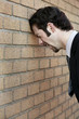 Foto: Businessman banging his head against the wall. Businessman banging his head against the wall.