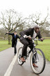 Businessman trying to beat another businessman with an umbrella.