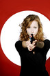 Businesswoman aiming a pistol at the camera.