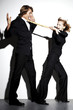 Businesswoman pulling a businessman's tie.