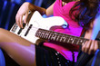 Young guitar player performing in night club
