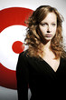 Businesswoman standing in front of a dartboard.