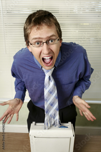 Photo: Businessman in shock after looking at his shredded tie. Businessman in shock after looking at his shredded tie.