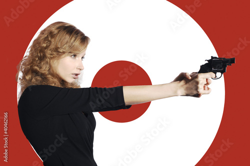 Photo: Businesswoman aiming a pistol. Businesswoman aiming a pistol.