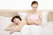 Man sleeping while his wife is sulking.
